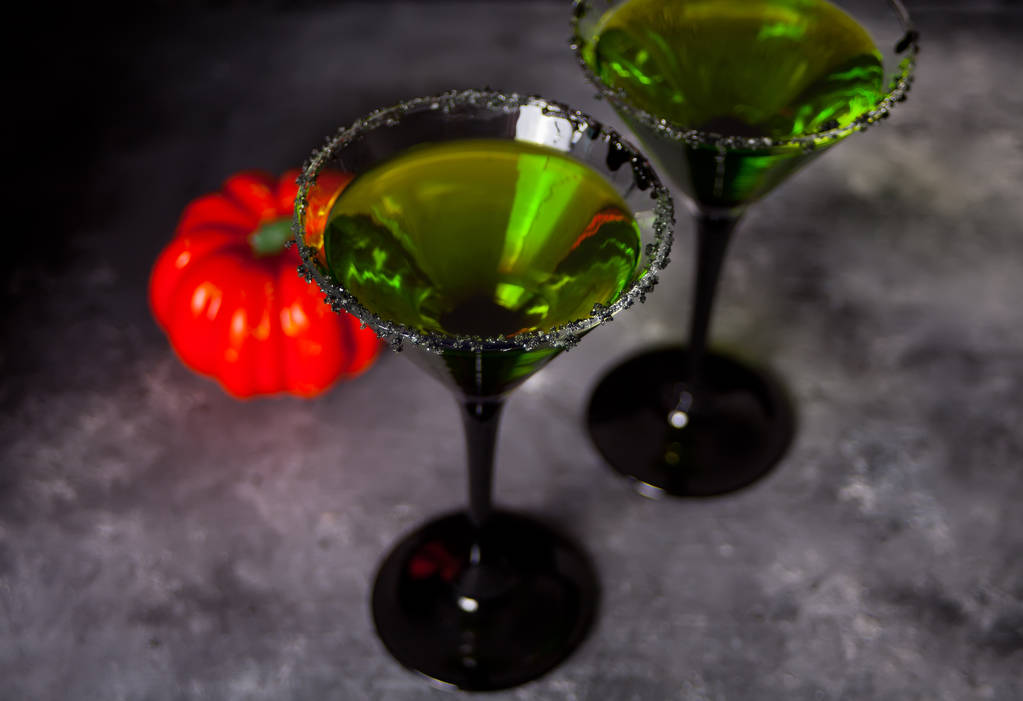 Δύο ποτήρια με πράσινο ζόμπι κοκτέιλ για αποκριάτικο πάρτι στο γκρι φόντο - Φωτογραφία, εικόνα