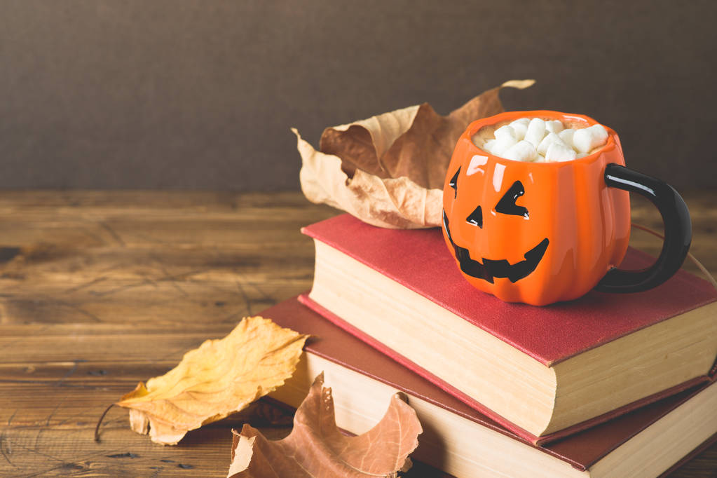 Conceito de feriado de Halloween com copo de chocolate quente, livros e autu
 - Foto, Imagem