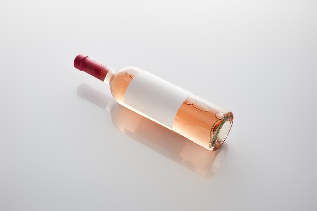 Flasche mit Rosenwein und leerem Etikett auf weißem Hintergrund - Foto, Bild