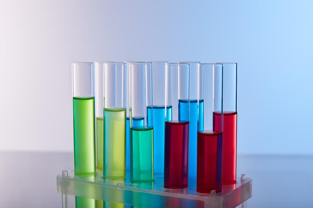 tubos de ensaio de vidro com líquido colorido sobre fundo azul
 - Foto, Imagem