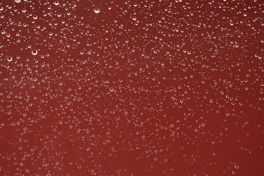 klare transparente Wassertropfen auf rotem Hintergrund - Foto, Bild