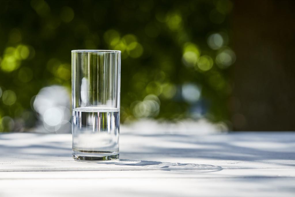 słodka czysta woda w przezroczystym szkle w słoneczny dzień na zewnątrz na drewnianym stole - Zdjęcie, obraz