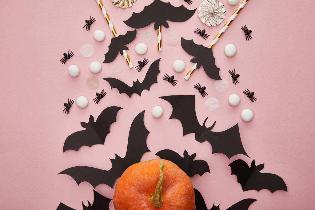 top view of pumpkin, bats and spiders on pink background, Halloween decoration - 写真・画像