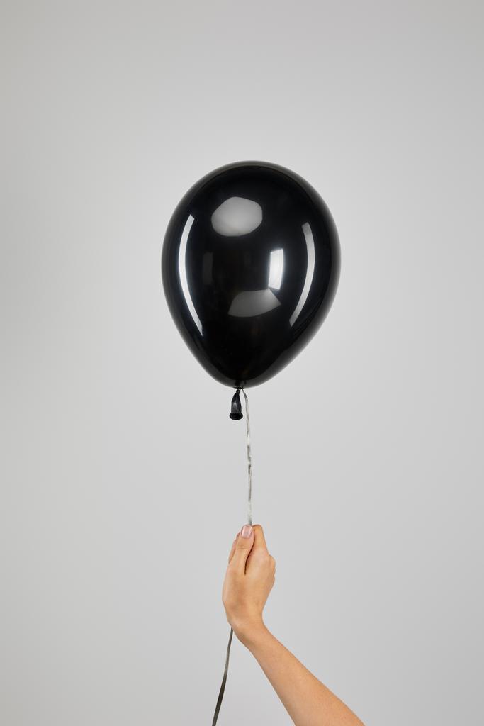 bijgesneden beeld van vrouw met zwarte ballon geïsoleerd op grijze, zwarte vrijdag concept - Foto, afbeelding