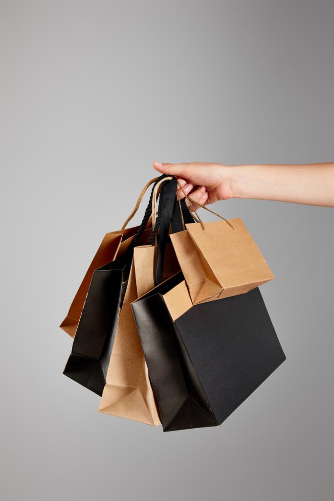 visão parcial da mulher segurando saco de compras de papel isolado no conceito cinza, preto sexta-feira
 - Foto, Imagem