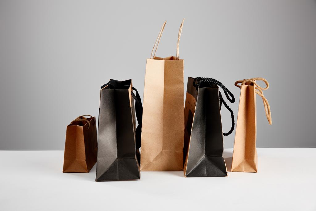 papír bevásárló táskák elszigetelt szürke, fekete péntek koncepció - Fotó, kép