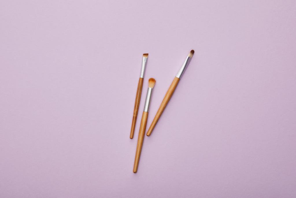 vista superior de cepillos de maquillaje aislados en violeta
  - Foto, Imagen