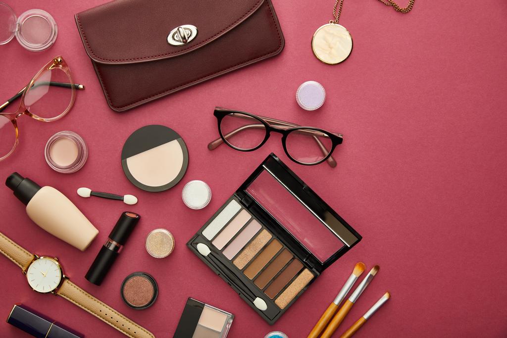 top view of brown bag near glasses and lipsticks on crimson  - Photo, Image