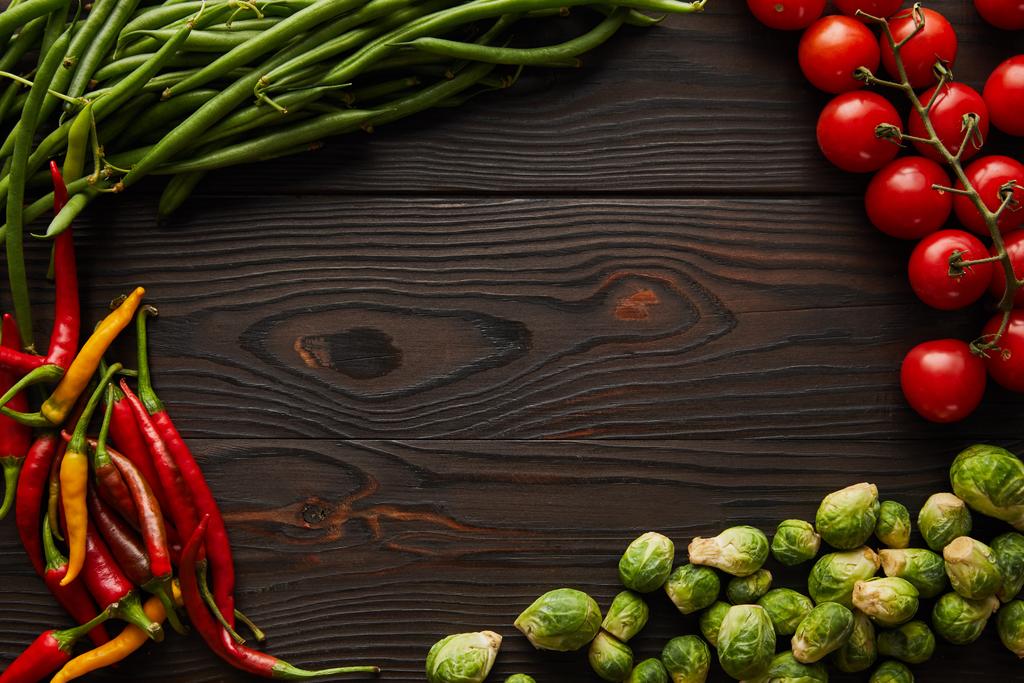 Kırmızı biber, kiraz domatesleri, yeşil bezelyeler, ahşap masada Brüksel lahanası.  - Fotoğraf, Görsel