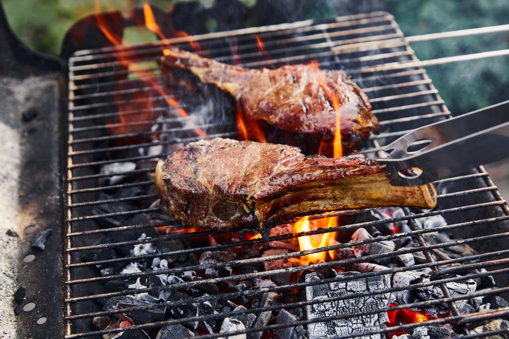 grelhar carne saborosa na grelha de churrasco e pedaços de carvão fora
  - Foto, Imagem