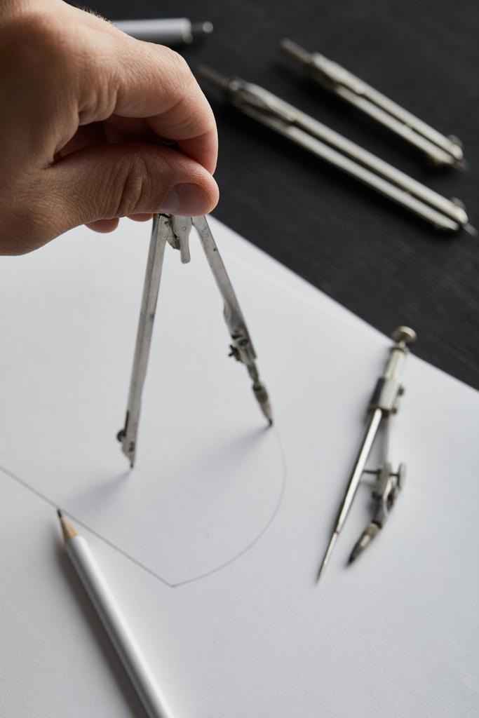 обрезанный вид человека рисовать круг на бумаге с компасом
 - Фото, изображение