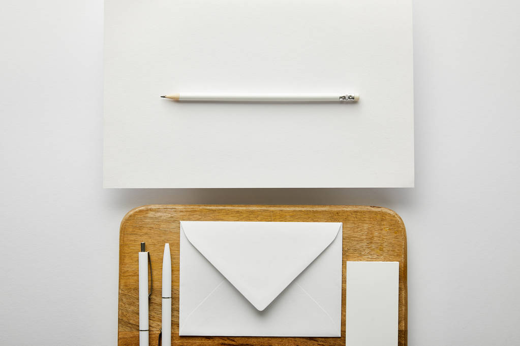 vista superior de sobre, tarjeta de visita y bolígrafos en tablero de madera, lápiz, papel
  - Foto, Imagen
