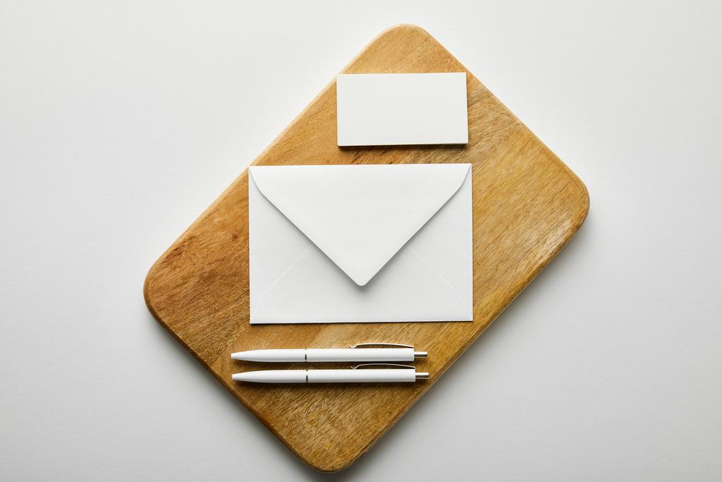 top view of envelope, business card and pens on wooden board - Photo, Image