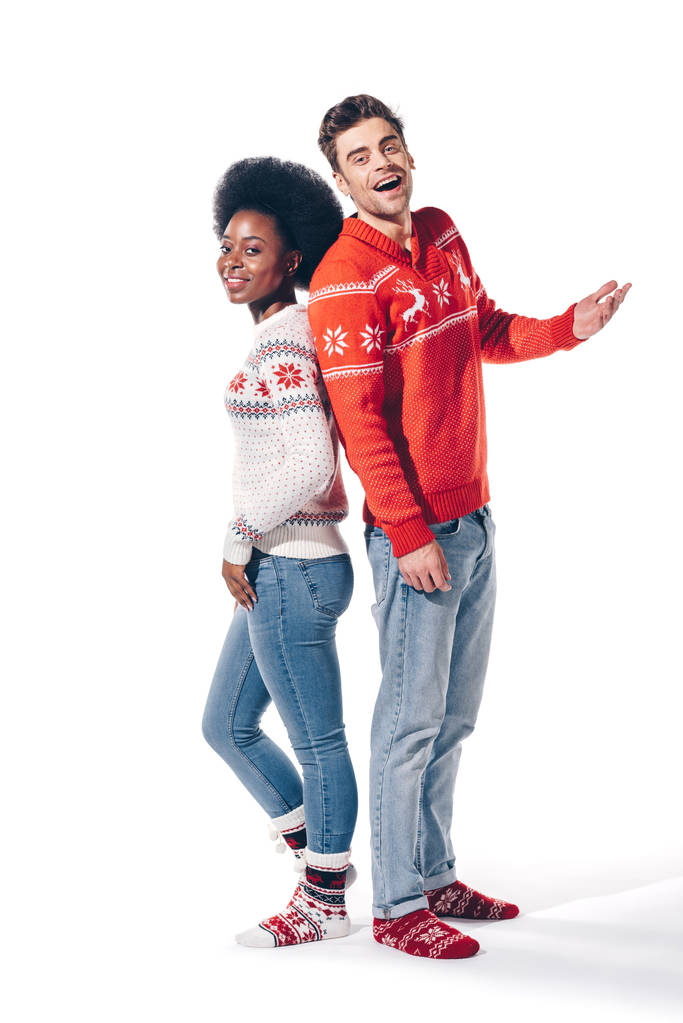 glückliches multikulturelles Paar, Rücken an Rücken stehend, isoliert auf weiß  - Foto, Bild