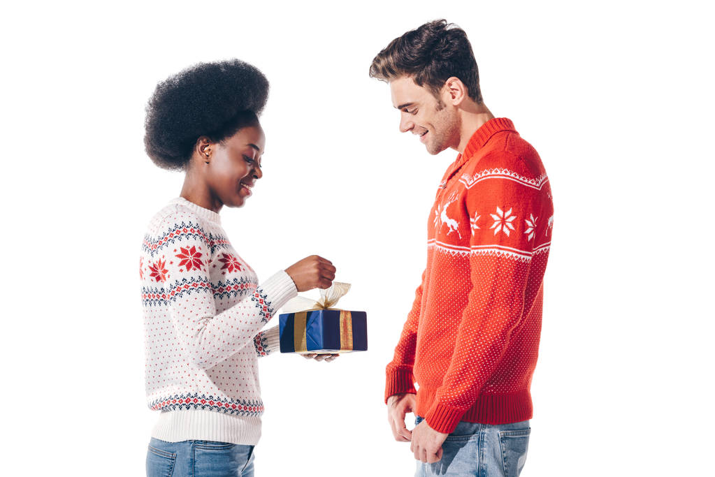 glückliches gemischtrassiges Paar mit Weihnachtsgeschenk, isoliert auf weiß - Foto, Bild