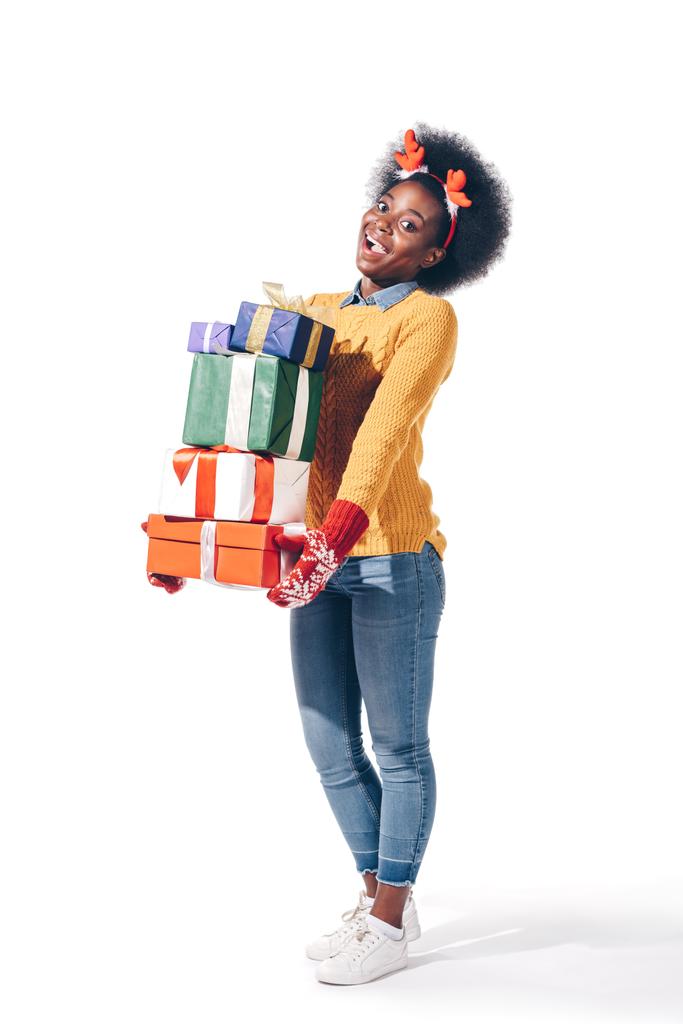 podekscytowany Afryki dziewczyna w Boże Narodzenie jelenie rogi trzymając pudełka prezentów, izolowane na białym - Zdjęcie, obraz