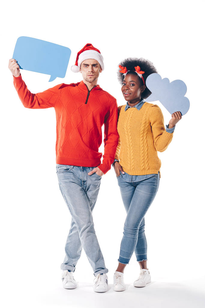 pareja interracial en sombrero de santa y cuernos de ciervo sosteniendo la burbuja del pensamiento y la burbuja del habla, aislado en blanco
 - Foto, imagen