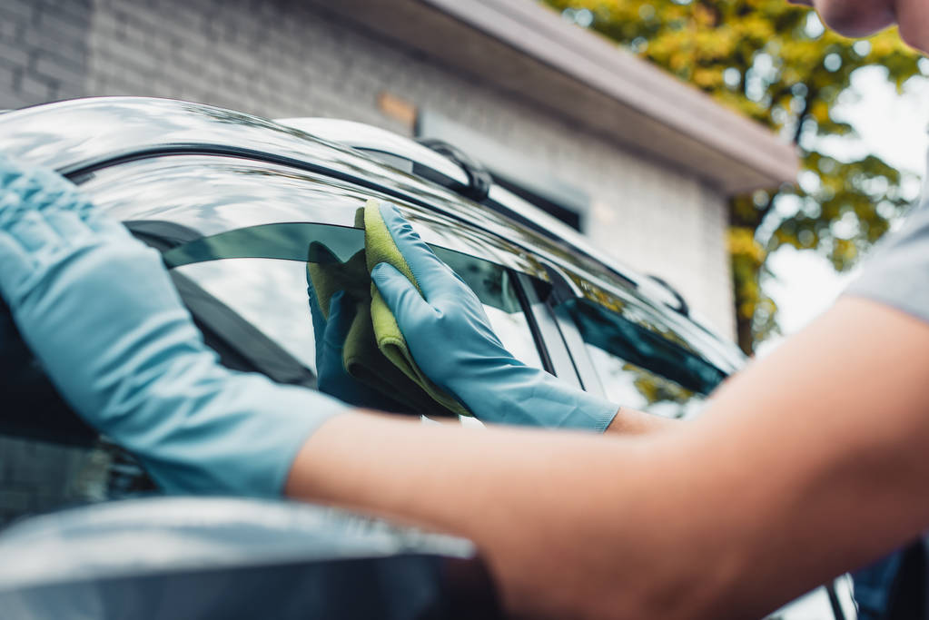 περικοπή άποψη του αυτοκινήτου καθαρότερο σκούπισμα παράθυρο πλευρά του αυτοκινήτου με κουρέλι - Φωτογραφία, εικόνα