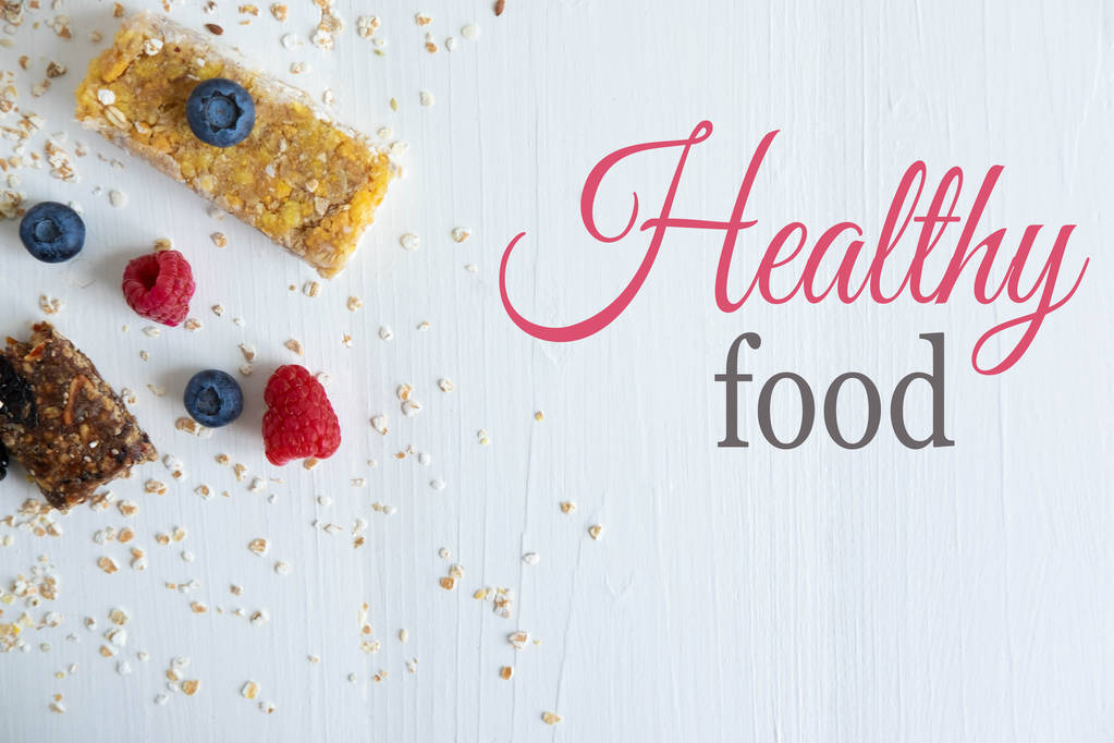 Healthy food. Granola cereal bars close-up with fresh raspberries and blackberries. A balanced diet for weight loss. Flat lay, top view. - Photo, Image