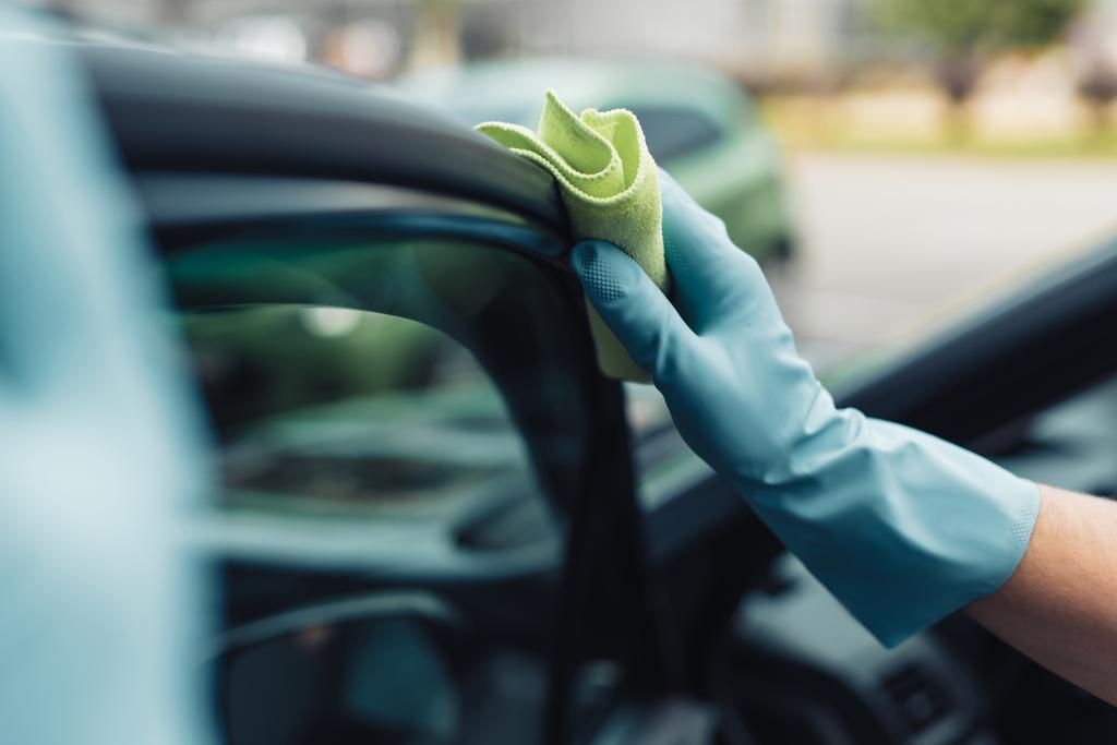 Kırpılmış araba temizleyicisi araba kapısını paçavrayla siliyor. - Fotoğraf, Görsel