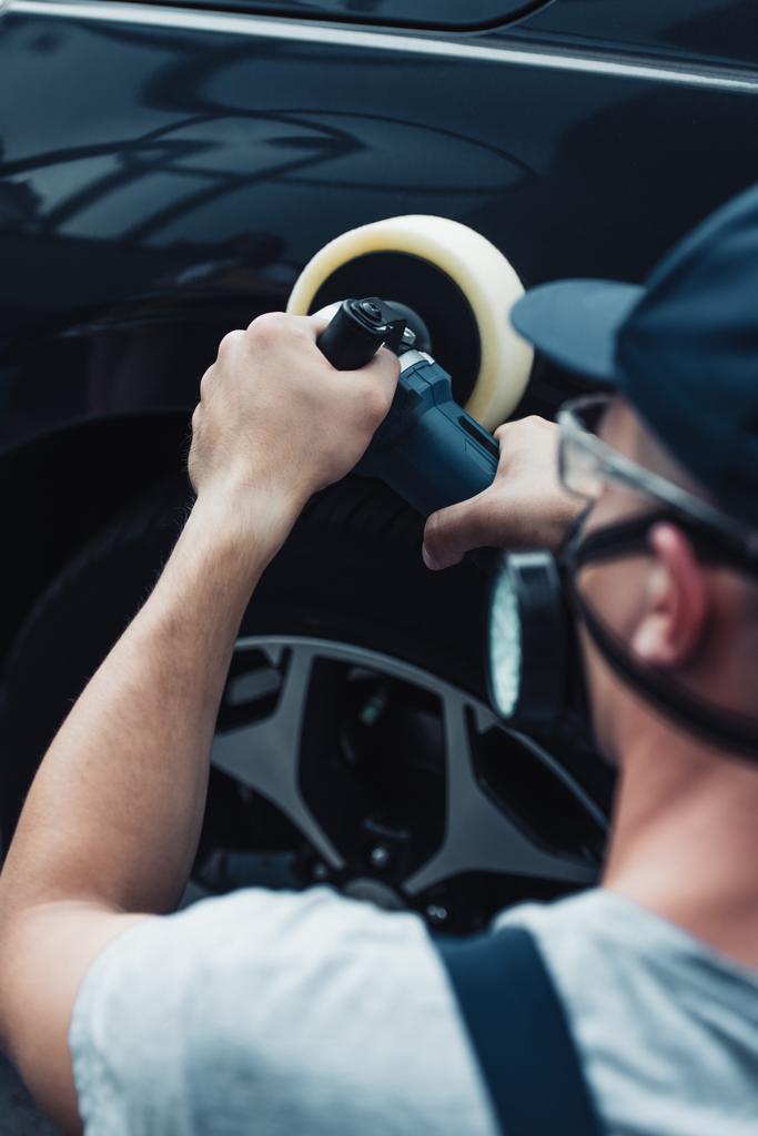 Koruyucu maske takan araba temizleyicisinin seçici odak noktası tampon makinesiyle arabayı cilalamak - Fotoğraf, Görsel