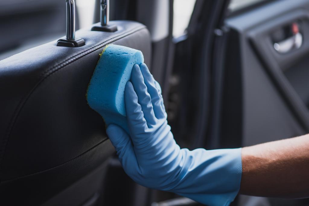 μερική άποψη του αυτοκινήτου καθαρότερο στο ελαστικό γάντι σκούπισμα κάθισμα αυτοκινήτου - Φωτογραφία, εικόνα