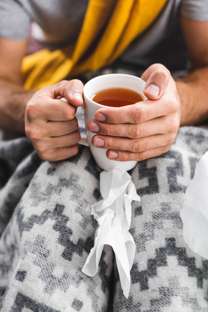 kivágott kilátás férfi gazdaság csésze tea az apartmanban  - Fotó, kép