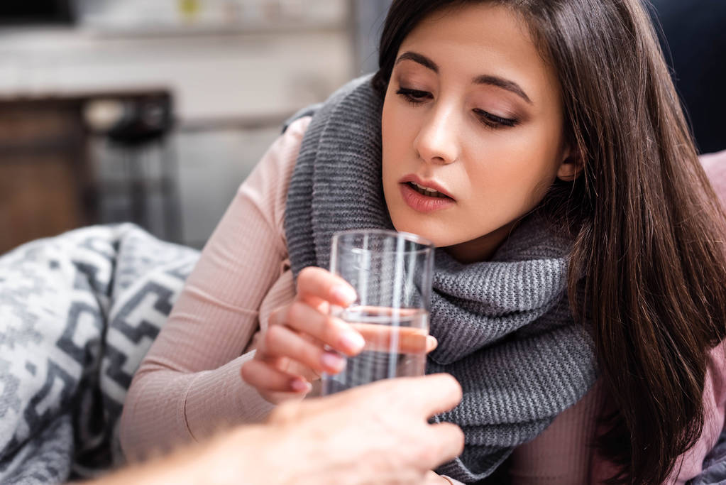 cropped view of boyfriend  giving glass of water to sick girlfriend  - Photo, Image