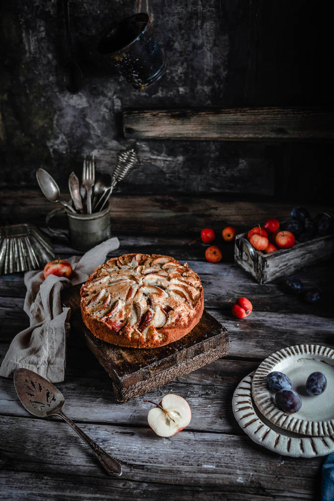delicioso pastel casero con manzanas y utensilio en la vieja mesa oscura
  - Foto, Imagen