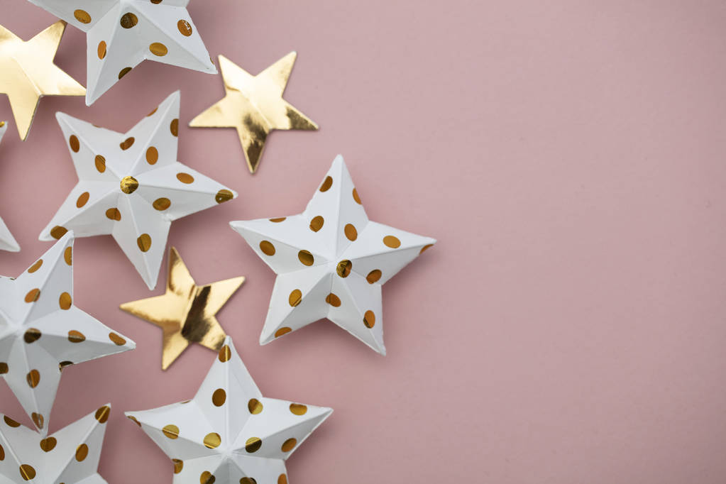 Decoraciones de estrellas blancas y doradas sobre un rosa pastel. Festi estacional
 - Foto, imagen