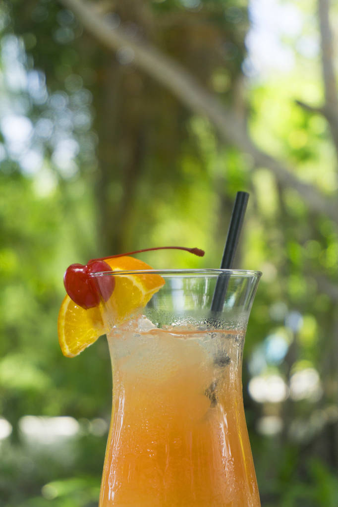 Cocktail tropical com guarnição de laranja e cereja
 - Foto, Imagem