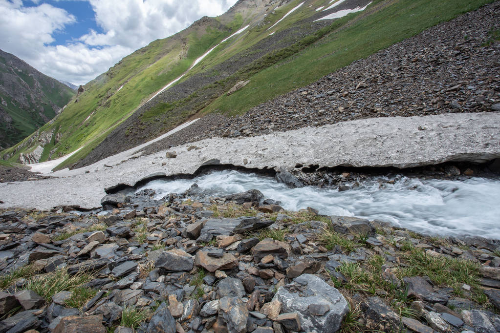 мальовничий вид на швидку гірську річку, що тече в скелястих горах навесні сонячний день
  - Фото, зображення