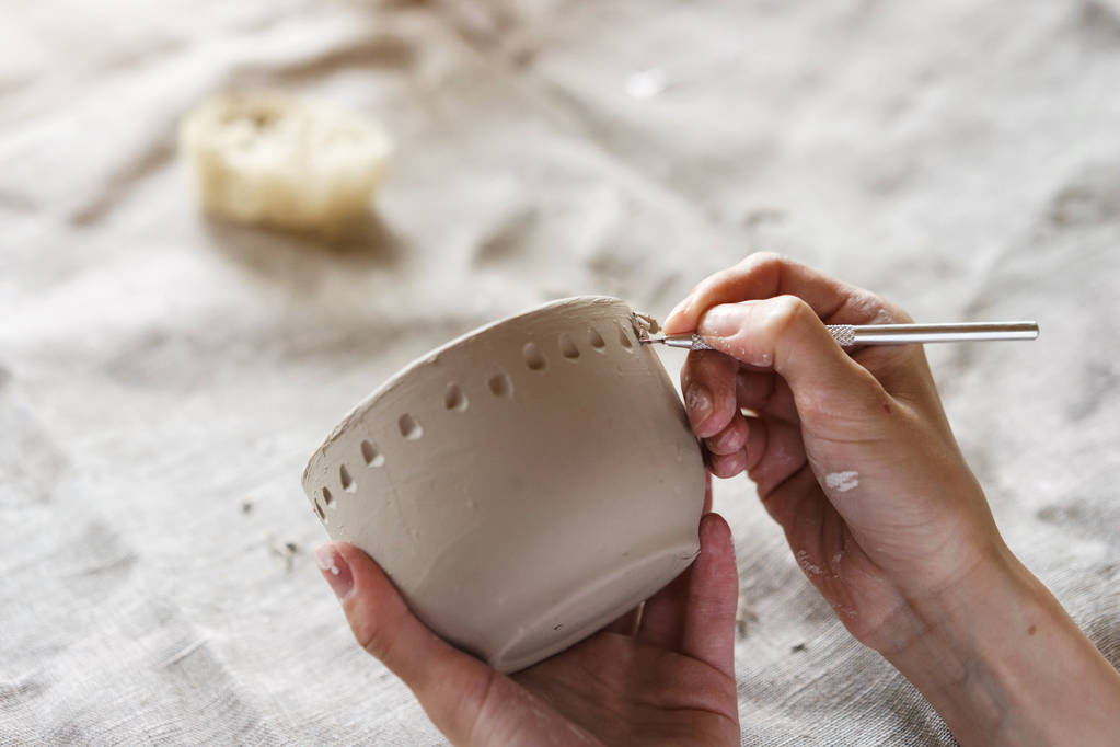 Kobiece ręce trzymać miskę do odlewania wyrobów glinianych. Metoda w kształcie do wytwarzania potraw z gliny. Prac ręcznych. Tworzenie ceramiki - Zdjęcie, obraz