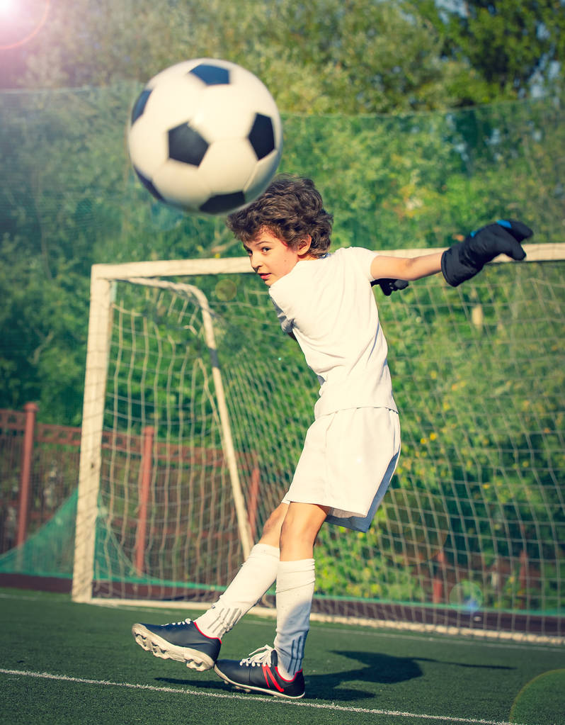 Θερινό τουρνουά ποδοσφαίρου για μικρό παιδί. Ποδοσφαιρική ομάδα. Συναισθήματα και χαρά του παιχνιδιού. Νέος τερματοφύλακας. Αγόρι τερματοφύλακας στο ποδόσφαιρο αθλητικών ειδών στο γήπεδο με μπάλα. Αθλητική ιδέα. επιλεκτική εστίαση - Φωτογραφία, εικόνα