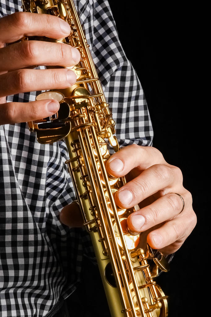 saksofon sopranowy w dłoniach na czarnym tle - Zdjęcie, obraz