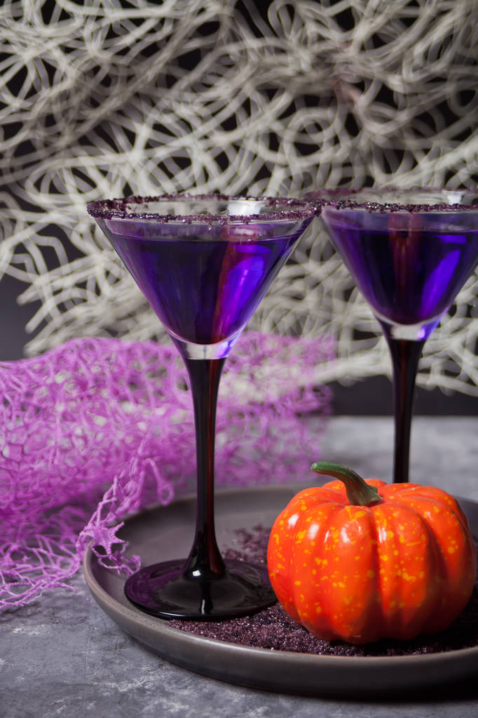 Dos vasos con cóctel púrpura, calabaza para la fiesta de Halloween en el fondo oscuro
 - Foto, imagen