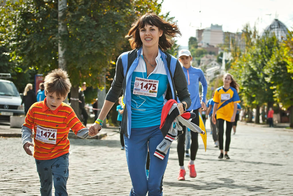 CHERNIVTSI, UCRANIA 29 DE SEPTIEMBRE. 2019: Los corredores que participan en la carrera de caridad "Bukovina Mile". Una corta carrera maratónica para apoyar la paz. Deportes para familias y un estilo de vida saludable
. - Foto, imagen