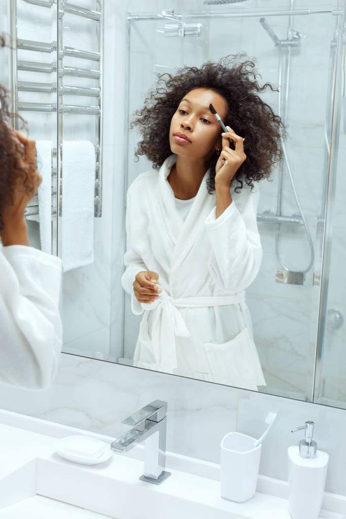 Makijaż piękności. Kobieta myjąca brwi pędzlem w łazience - Zdjęcie, obraz