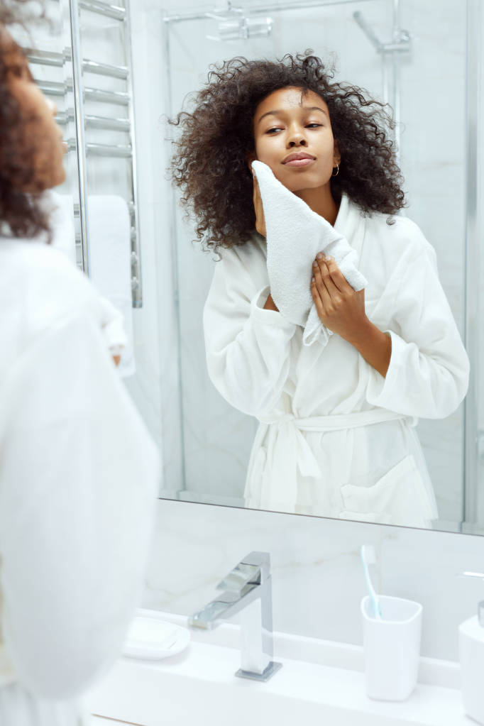 Lavando la cara. Mujer secando piel con toalla en el baño
 - Foto, Imagen
