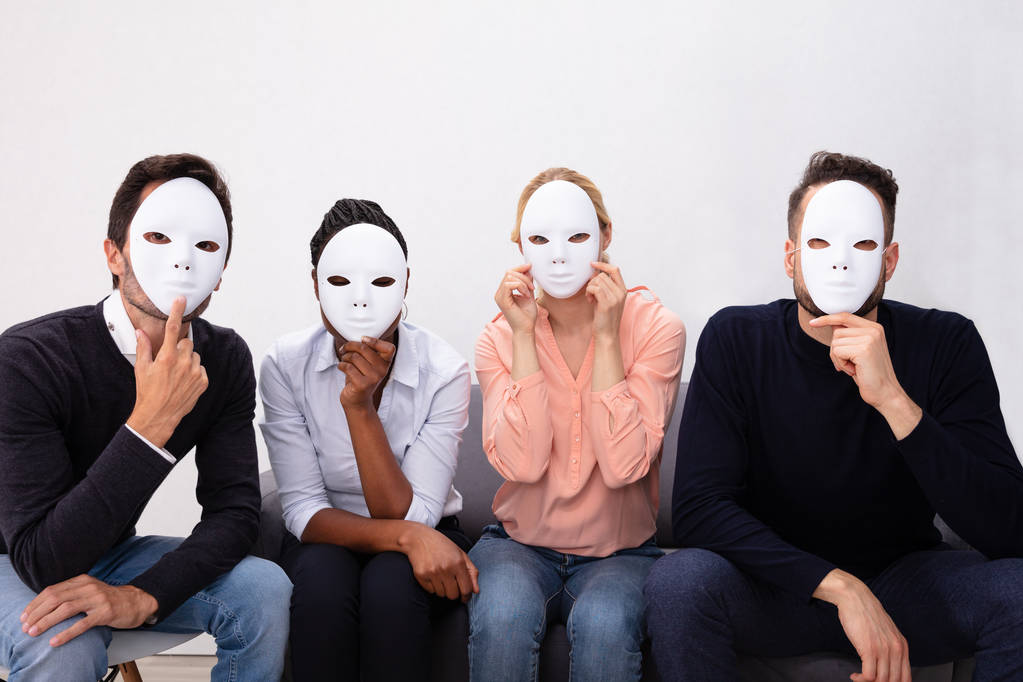Gruppe von Menschen, die zusammen stehen und sein Gesicht mit weißen Masken bedecken - Foto, Bild