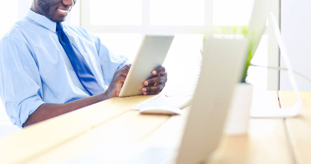 Afrykański amerykański biznesmen na słuchawkach pracuje na swoim laptopie - Zdjęcie, obraz