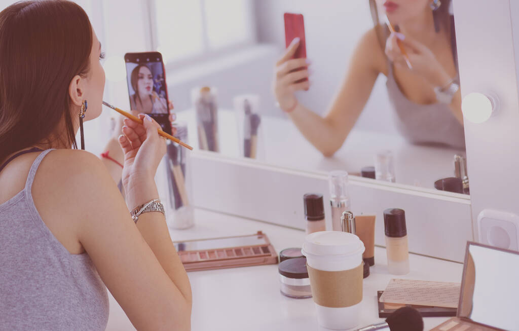 Beleza blogger filmando tutorial de maquiagem com smartphone na frente do espelho
 - Foto, Imagem