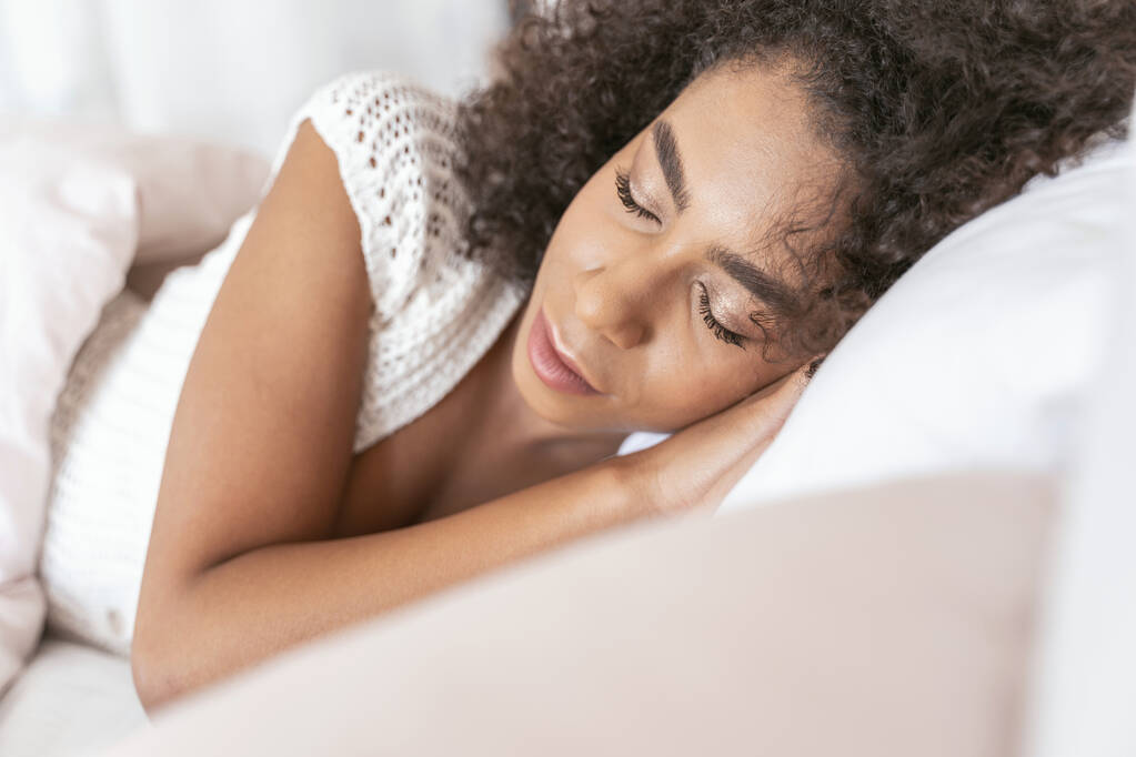 Zrelaksowana brunetka śpiąca w swoim miękkim, przytulnym łóżku - Zdjęcie, obraz