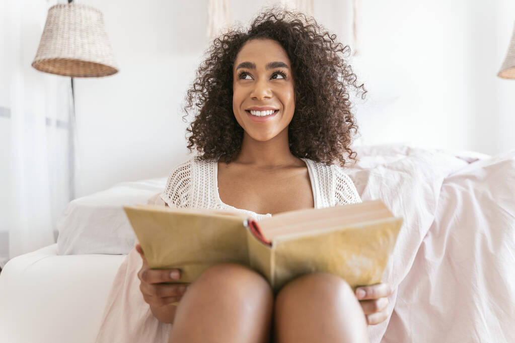 Joven alegre persona femenina leyendo libro grueso
 - Foto, imagen