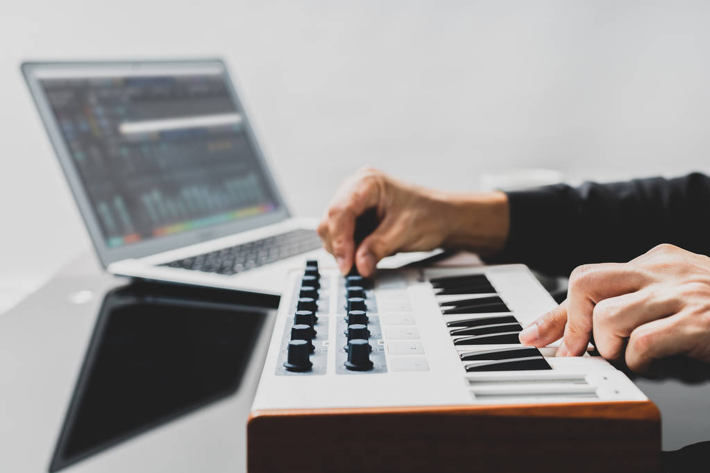 produtor musical masculino organizar e misturar uma música no teclado midi e computador portátil em estúdio em casa
 - Foto, Imagem