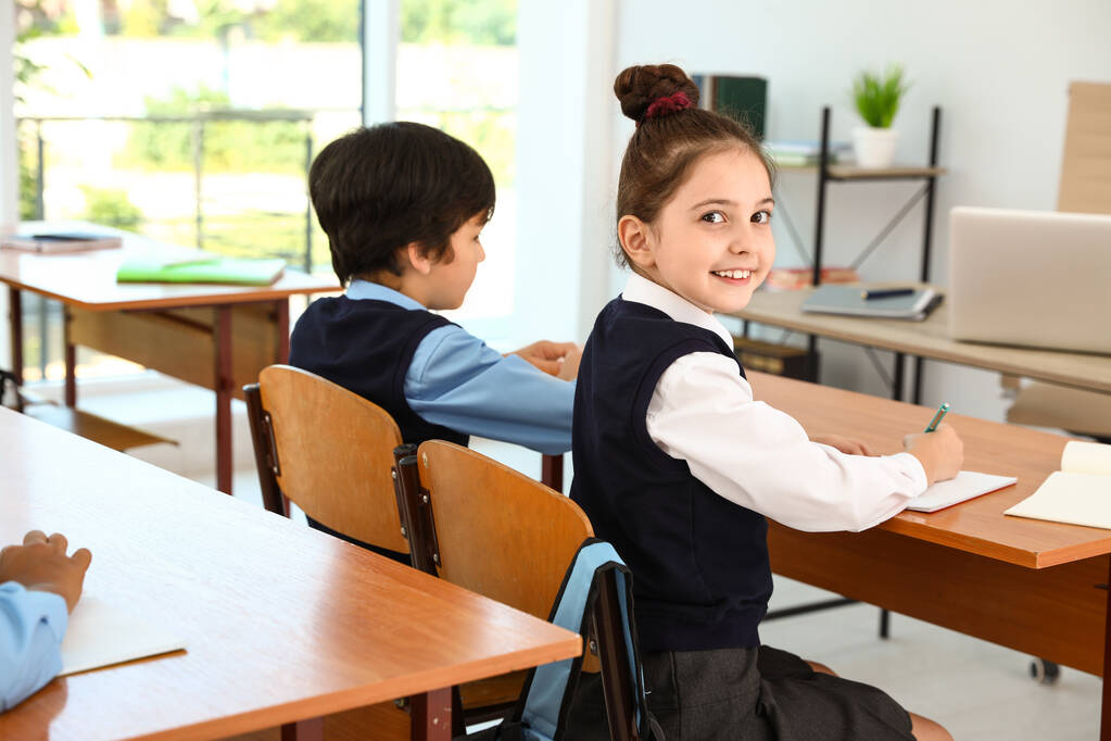 Mädchen trägt neue Schuluniform im Klassenzimmer - Foto, Bild