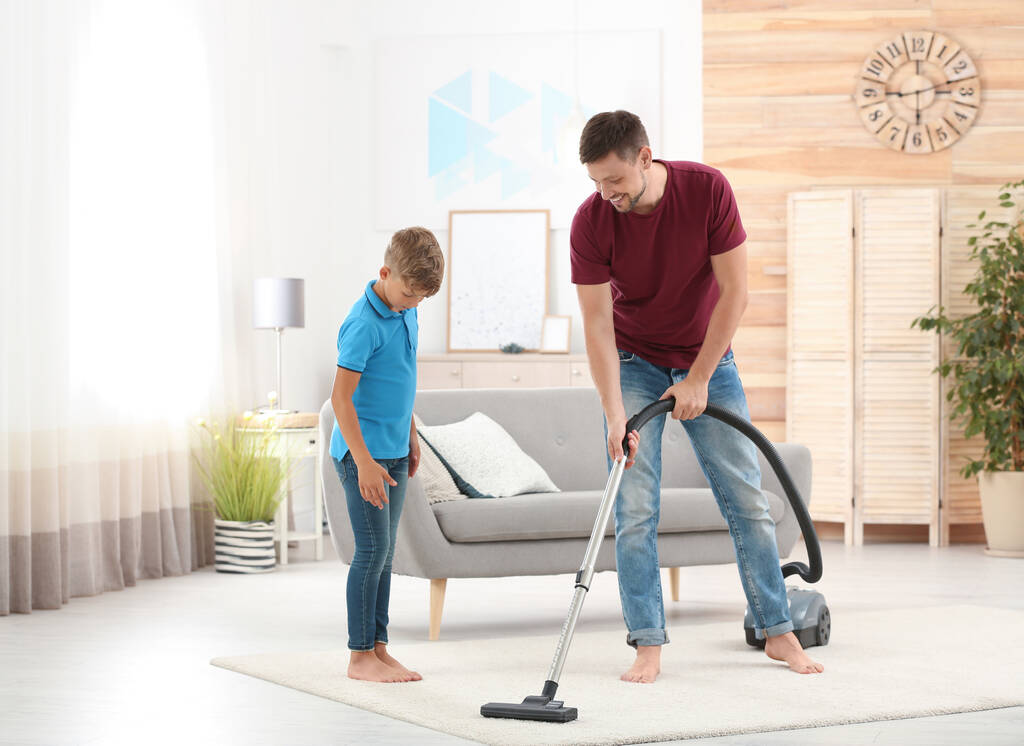 Vater und Sohn putzen gemeinsam Wohnzimmer - Foto, Bild
