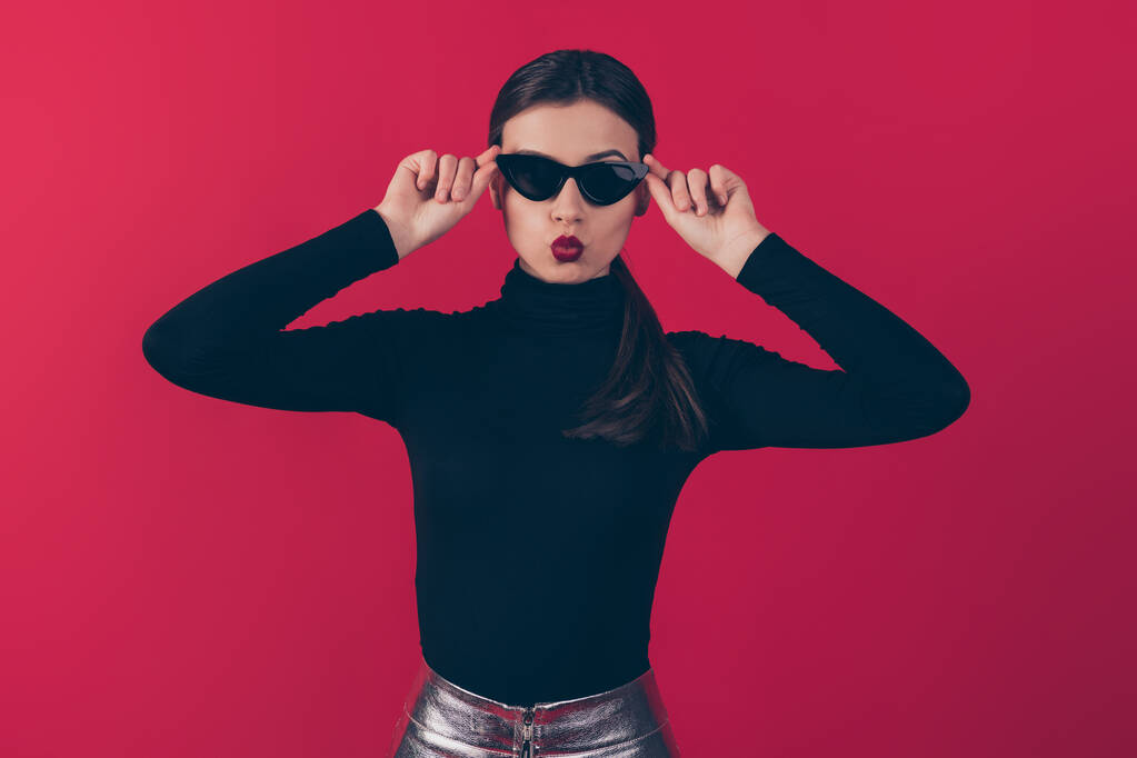 Portrait of attractive magnificent lady wear eyewear eyeglasses charming coquette want date attract rich wealthy guy send air kisses have black outfit silver skirt isolated over red color background - Photo, Image