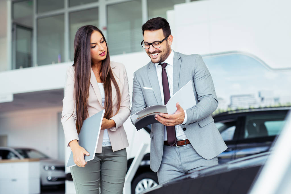 Professional salesperson selling cars at dealership to buyer - Photo, Image