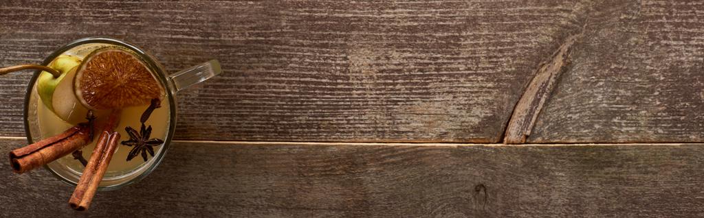 вид зверху на традиційний теплий грушевий глінтвейновий коктейль зі спеціями та сушеними цитрусами на дерев'яному сільському столі, панорамний знімок
 - Фото, зображення